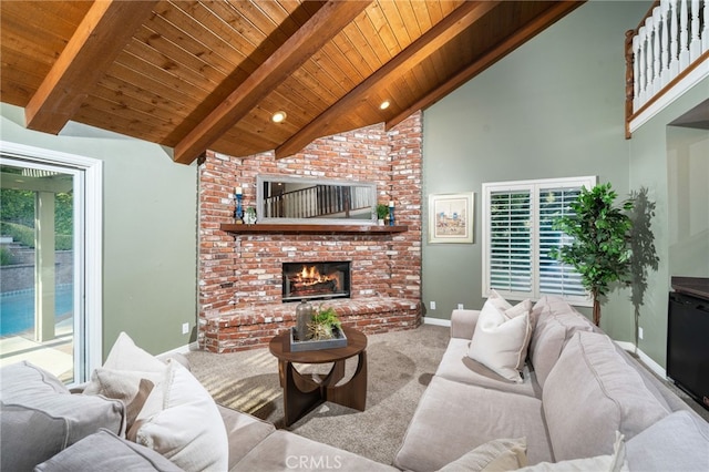 carpeted living room featuring a fireplace, beamed ceiling, baseboards, high vaulted ceiling, and wooden ceiling