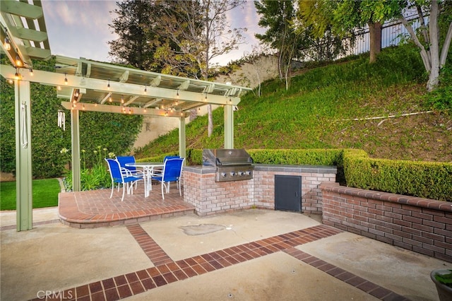 view of patio with an outdoor kitchen, a pergola, and grilling area