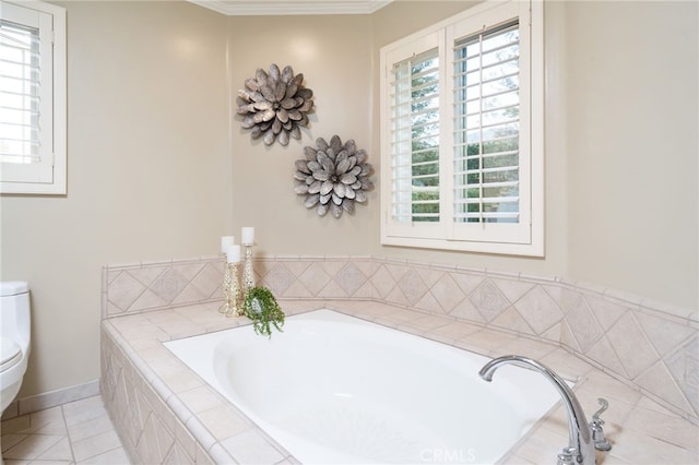 bathroom featuring crown molding, toilet, a healthy amount of sunlight, and a garden tub