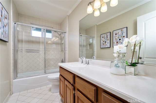 bathroom featuring tile patterned flooring, crown molding, vanity, toilet, and bath / shower combo with glass door