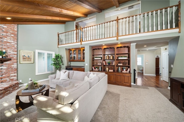 living room with high vaulted ceiling, baseboards, wood ceiling, and light colored carpet