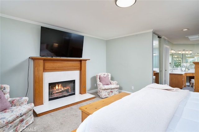 bedroom with carpet floors, ornamental molding, a glass covered fireplace, and ensuite bathroom