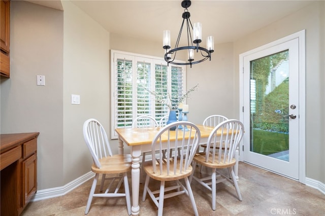 dining space featuring baseboards and a notable chandelier