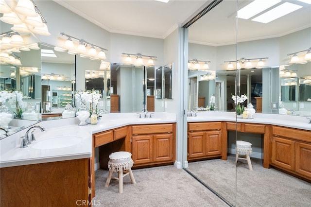 bathroom with crown molding, double vanity, a skylight, and a sink