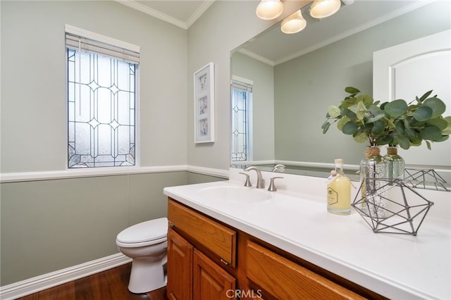 half bath featuring toilet, ornamental molding, wood finished floors, and vanity