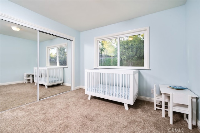 carpeted bedroom featuring baseboards, a closet, and multiple windows
