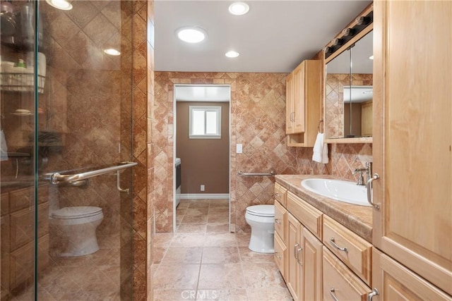 bathroom featuring toilet, tile walls, a shower stall, and vanity