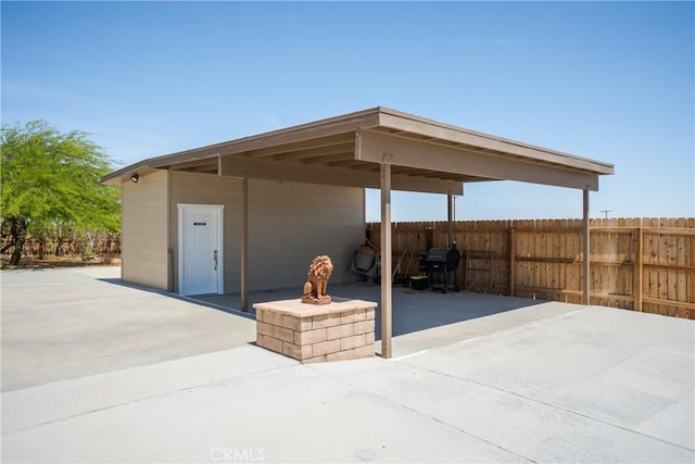 view of patio / terrace with fence and a carport
