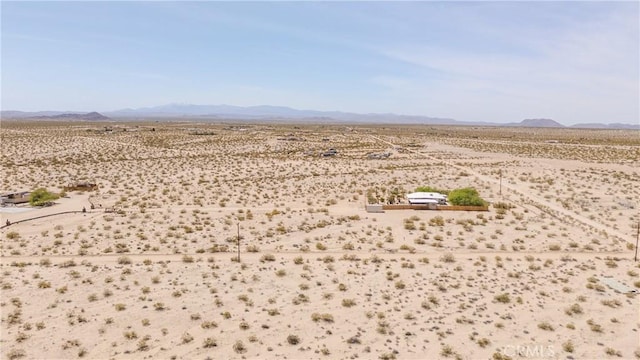drone / aerial view featuring view of desert, a mountain view, and a rural view