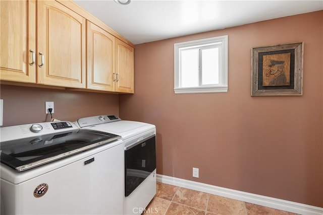 washroom featuring baseboards, cabinet space, and independent washer and dryer