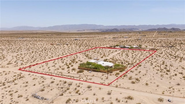 drone / aerial view with view of desert, a mountain view, and a rural view