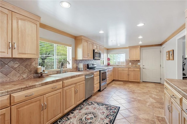 kitchen featuring plenty of natural light, a sink, light brown cabinets, and stainless steel appliances
