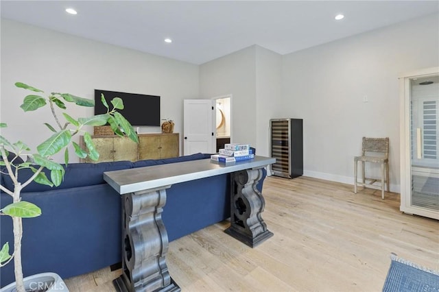 office space featuring baseboards, light wood-style flooring, recessed lighting, and beverage cooler