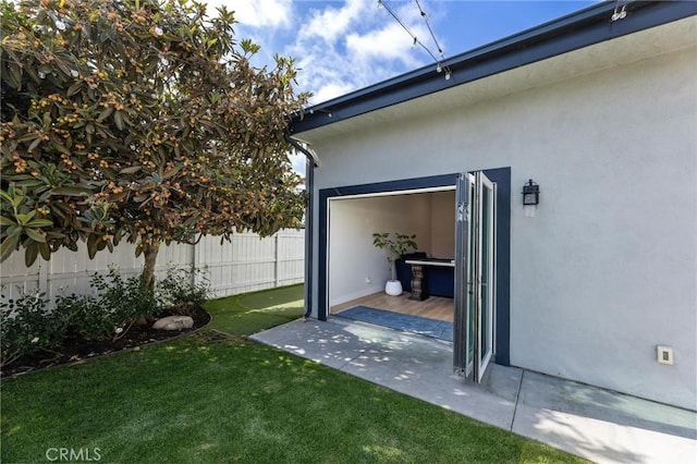 exterior space with a yard, fence, and stucco siding