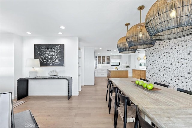 dining area with light wood finished floors and recessed lighting
