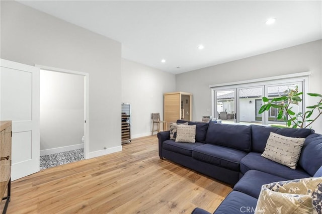 living room featuring light wood finished floors, baseboards, and recessed lighting