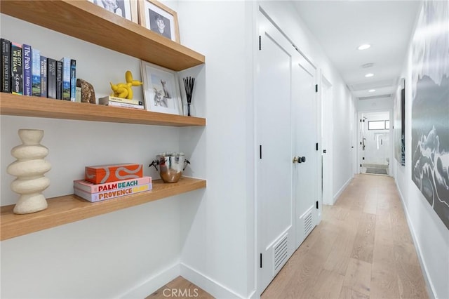 hallway featuring recessed lighting, baseboards, and light wood-style floors