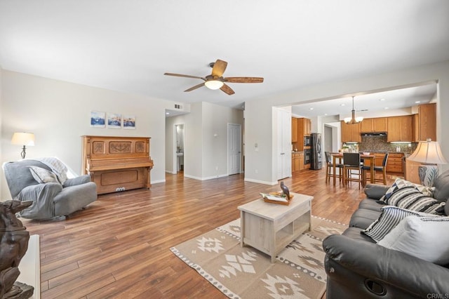 28829 Golden Dawn Dr, Menifee, CA 92584 - living room featuring visible vents, baseboards, recessed lighting, light wood finished floors, and ceiling fan with notable chandelier