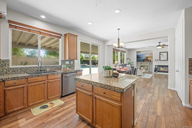 28829 Golden Dawn Dr, Menifee, CA 92584 - kitchen with decorative backsplash, light wood-type flooring, a sink, ceiling fan with notable chandelier, and dishwasher