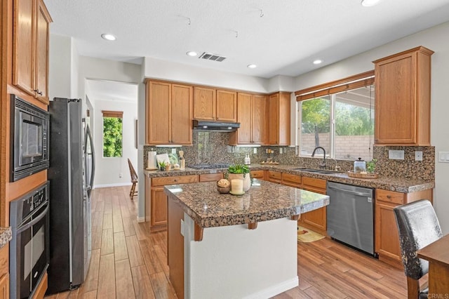28829 Golden Dawn Dr, Menifee, CA 92584 - kitchen with a sink, a kitchen island, black appliances, and light wood-style flooring