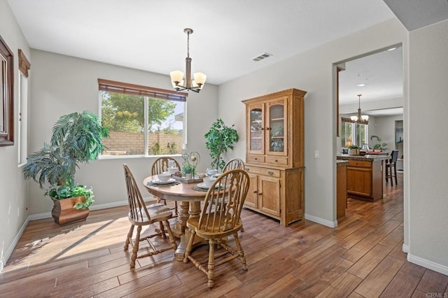 28829 Golden Dawn Dr, Menifee, CA 92584 - dining space featuring baseboards, an inviting chandelier, visible vents, and hardwood / wood-style floors