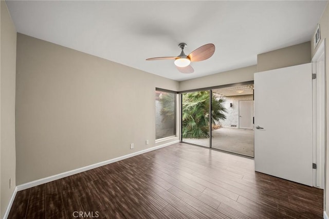 unfurnished room featuring baseboards, visible vents, wood finished floors, and a ceiling fan