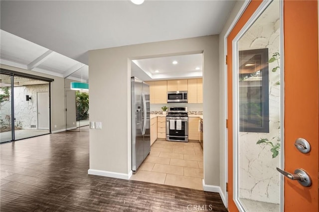 kitchen featuring stainless steel appliances, light brown cabinets, baseboards, light countertops, and light wood-style floors