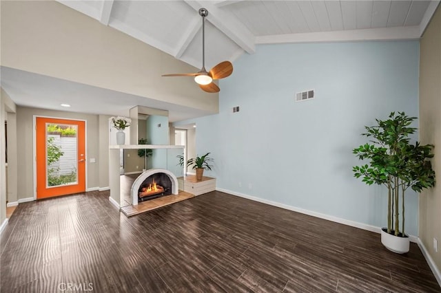 unfurnished living room with a lit fireplace, baseboards, visible vents, and wood finished floors