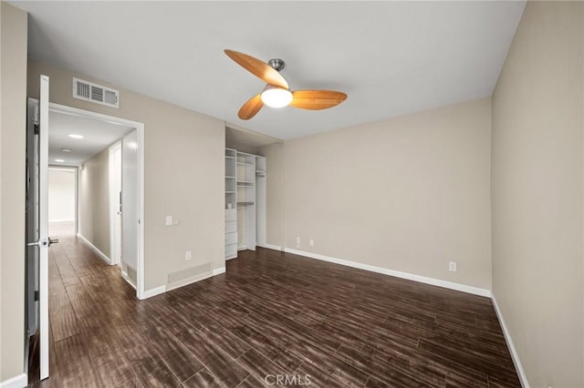 interior space with baseboards, dark wood-style flooring, and visible vents