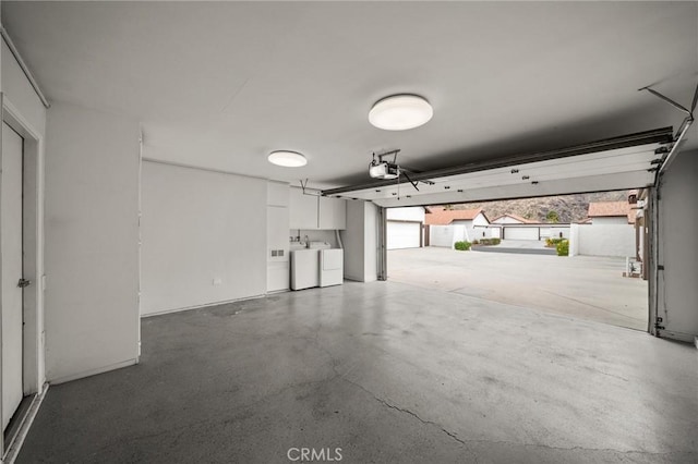 garage with washer and clothes dryer and a garage door opener