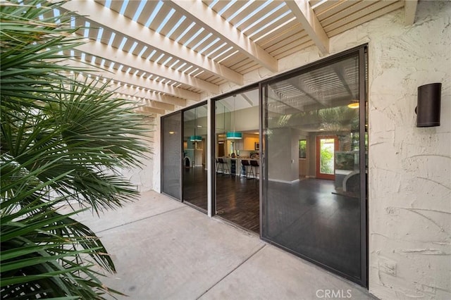 view of exterior entry with a pergola