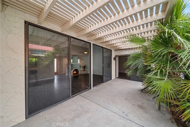 view of exterior entry with a patio and a pergola