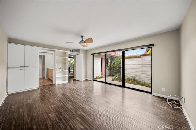 unfurnished living room with baseboards, dark wood-type flooring, and a ceiling fan