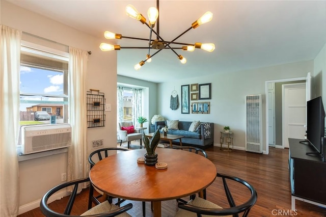 dining room with baseboards, a heating unit, an inviting chandelier, and wood finished floors
