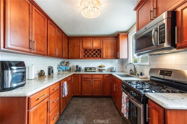 kitchen with a sink, backsplash, stainless steel appliances, and light stone countertops