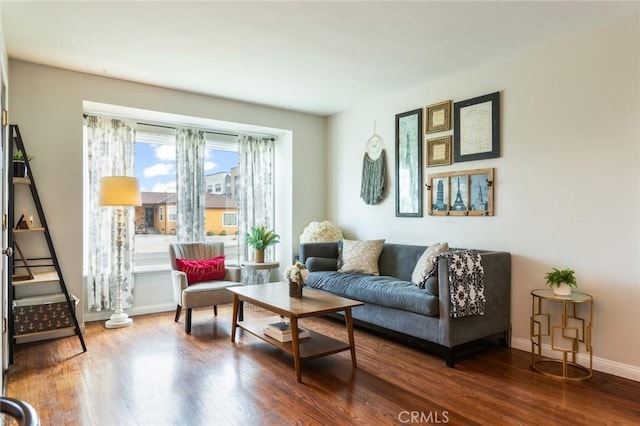 living area with baseboards and wood finished floors