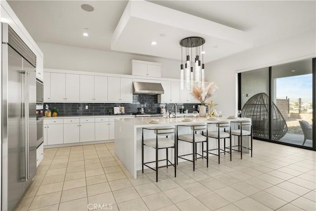 11818 N Hillsborough Ln, Porter Ranch, CA 91326 - kitchen with wall chimney range hood, built in fridge, decorative backsplash, light tile patterned floors, and recessed lighting