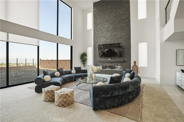 11818 N Hillsborough Ln, Porter Ranch, CA 91326 - living room with a high ceiling, healthy amount of natural light, a glass covered fireplace, carpet flooring, and baseboards