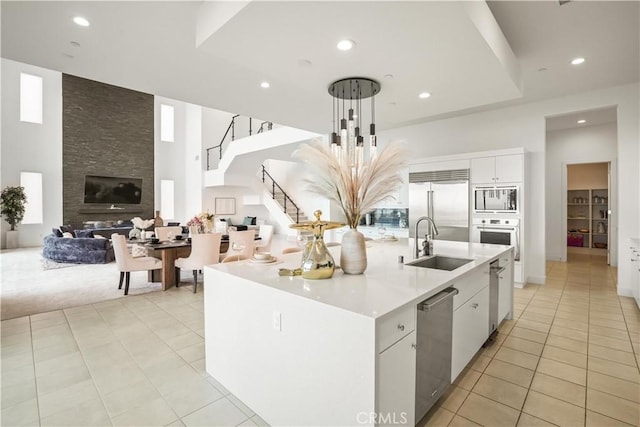11818 N Hillsborough Ln, Porter Ranch, CA 91326 - kitchen featuring built in appliances, a sink, light tile patterned floors, open floor plan, and light countertops