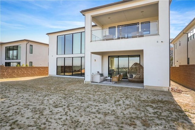 11818 N Hillsborough Ln, Porter Ranch, CA 91326 - rear view of house featuring a balcony, a patio area, stucco siding, and outdoor lounge area