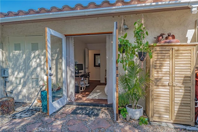 entrance to property featuring stucco siding and a tiled roof