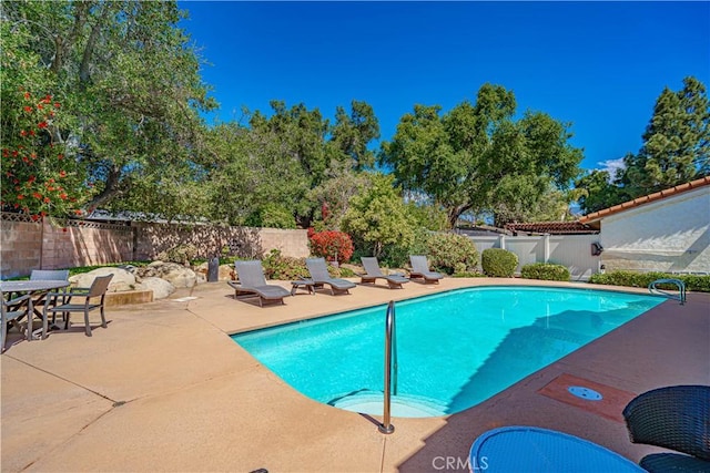 view of pool featuring a patio, a fenced in pool, and a fenced backyard