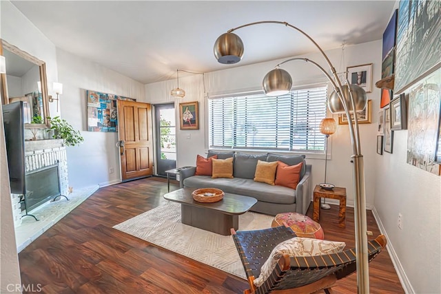 living room featuring plenty of natural light, baseboards, wood finished floors, and a fireplace