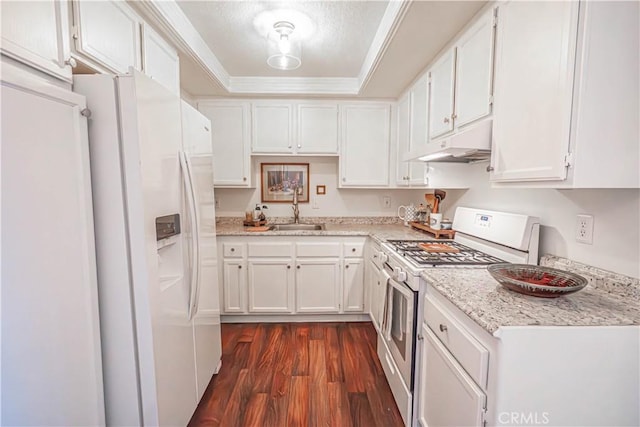 kitchen with white cabinets, a sink, white appliances, under cabinet range hood, and a tray ceiling