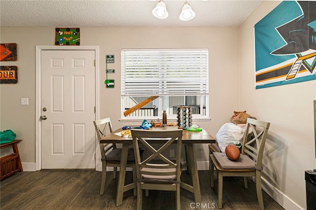 dining room with baseboards, a textured ceiling, and dark wood finished floors