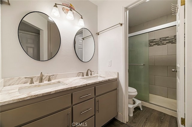 bathroom with toilet, a shower stall, and a sink
