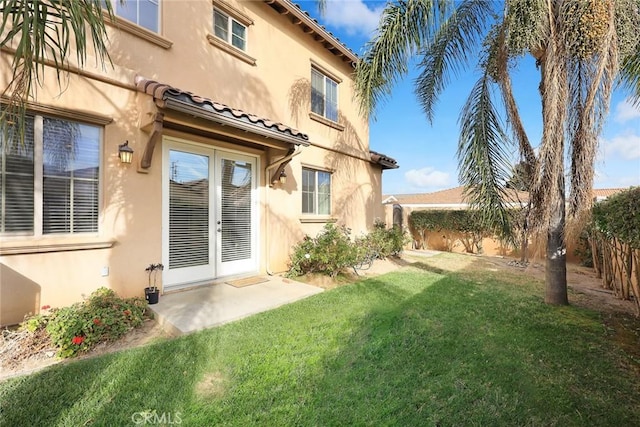 exterior space with a yard, a tiled roof, fence, and stucco siding