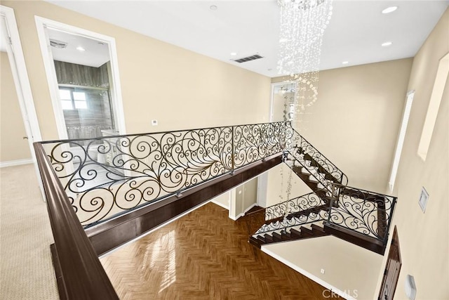 staircase with recessed lighting, baseboards, an inviting chandelier, and visible vents