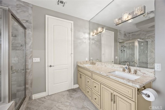 bathroom with a sink, a stall shower, marble finish floor, and visible vents