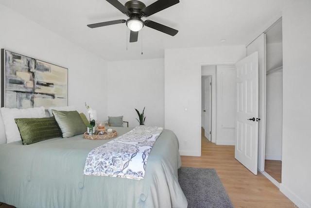 bedroom featuring baseboards, ceiling fan, and light wood-style floors